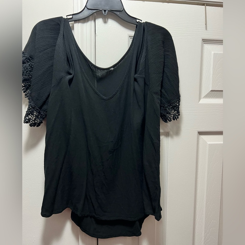 Cold shoulder blouse with crocheted sleeve trim.